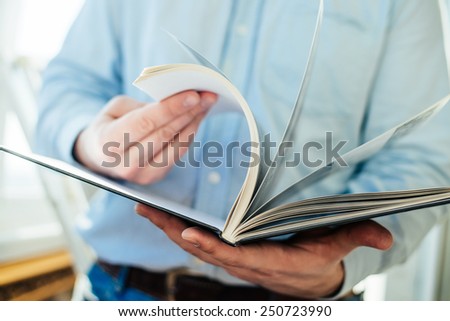 Closeup on a man reading a magazine. Tinted.