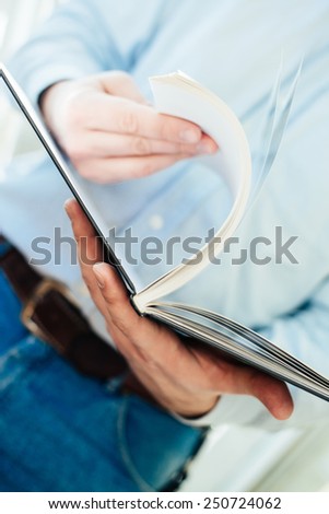 Closeup on a man reading a magazine. Tinted.