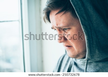 young desperate man wearing hood looking dangerous and underground in deep depression , pain and emotional disorder, grief and desperation
