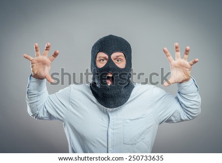 Face of a angry burglar wearing a black ski mask or balaclava