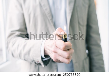 adult hand lighting a lighter and the warm flame