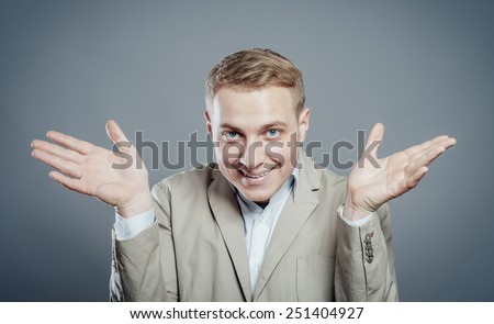 Closeup portrait of angry, annoyed unhappy young man, arms out asking what's the problem who cares so what, I don't know. Isolated on gray background.