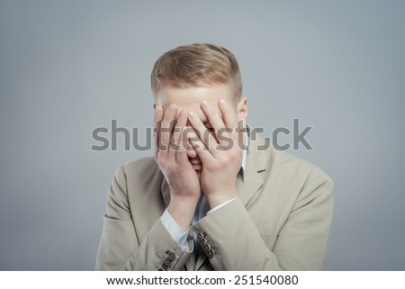 Closeup portrait of unhappy guy, sad thoughtful young business man thinking deeply, bothered by mistakes, hand on head looking downwards, having headache . Negative emotion