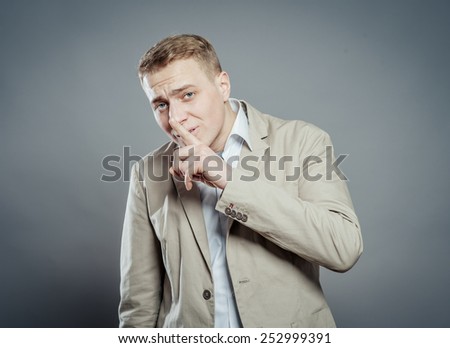 Businessman with finger on lips asking for silence
