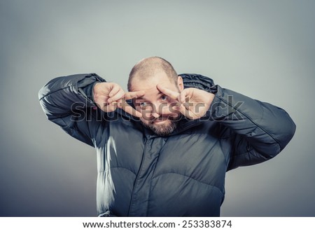 Close-up portrait of a young man covering face with his hands with enough space to look through the isolated gray background. Negative human emotions facial expression feelings, reactions.
