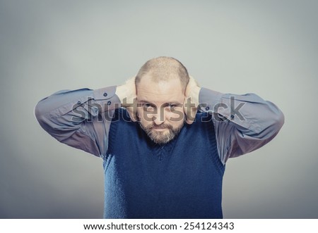 young man shows he does not want to hear . Fingers in his ears
