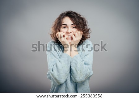 Close-up portrait of surprised beautiful girl holding her head in amazement and open-mouthed.