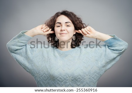 Do not want to hear anything. Young woman closing ears with hands, isolated