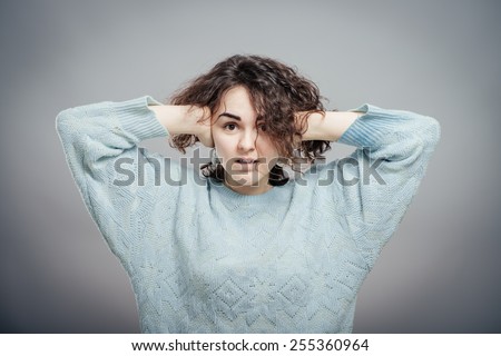 Do not want to hear anything. Young woman closing ears with hands, isolated