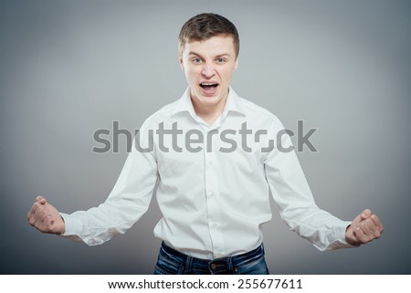 Successful young businessman celebrating his victory isolated on gray background