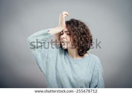 A young attractive woman suffering from illness or headache holding her head. Isolated