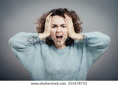 Closeup portrait of young, upset, sad depressed, worried, troubled brunette woman holding her head with both hands, isolated. Human emotions, face expressions, feelings, perception