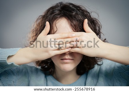 young girl covering her eyes over isolated white background