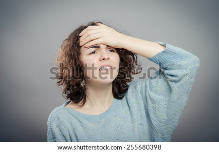 A young attractive woman suffering from illness or headache holding her head. Isolated