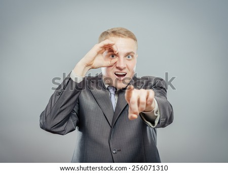 man with hand over eyes, looking through fingers