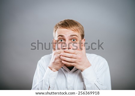 young scared adult with hand covering mouth