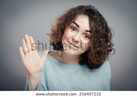 Closeup portrait, young, curly, brown hair woman, making five times sign gesture with hand fingers, isolated gray background. Positive human emotion facial expression feelings, attitude, symbol.