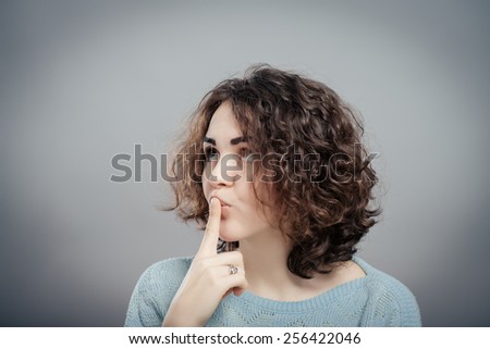 Portrait of casual woman with finger on lips
