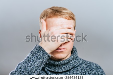 Closeup of young man hiding face whit hands
