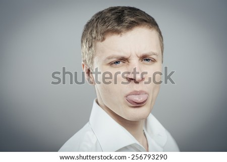 Adult man with bad manners - showing his tongue