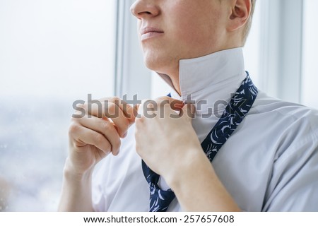 young man tie a tie