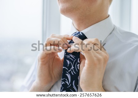 young man tie a tie