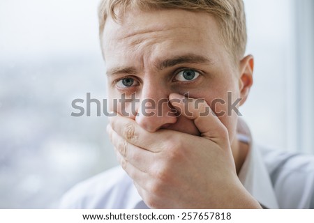 young scared with hand covering mouth