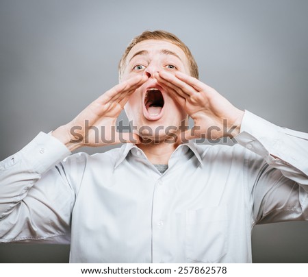 Photo of shouting man with his palms open by mouth looking upwards