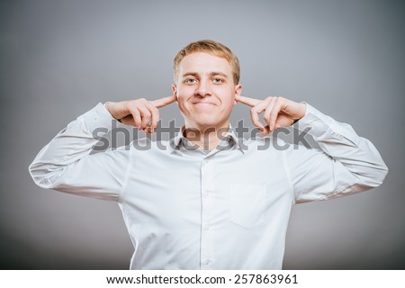 Annoyed businessman covering his ears with his hands