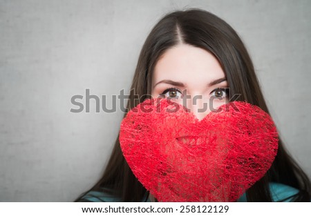 Young happy woman hold Love symbol red heart. Isolated on studio background female model.
