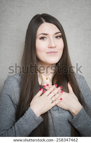 Joyful businesswoman holding hands on his chest