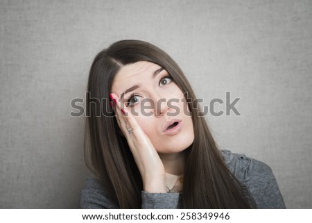 young, upset, worried, troubled brunette woman holding her head with hand