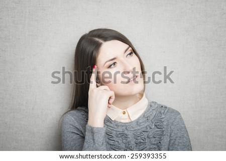 young woman thinks his finger to her temple