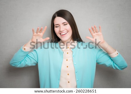 Attractive and pretty young girl with hands up . Stop or surrender gesture.