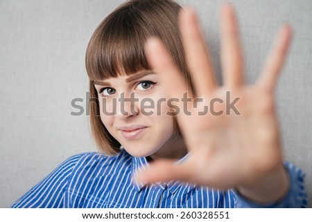 Portrait of a young woman smiling and saying hello at you
