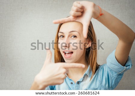 woman making a frame out of hand. isolated on gray background