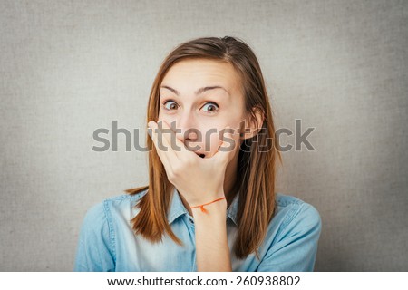 Young scared woman covering the mouth.cute girl embarrassed