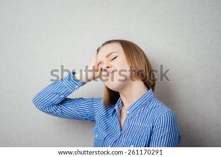 Portrait of unhappy young woman holding hands in head - isolated on gray background