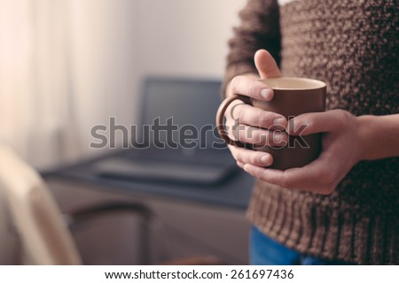 close up of man hands holding cup of coffee