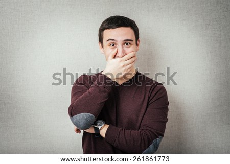 man covers his mouth so as not to laugh