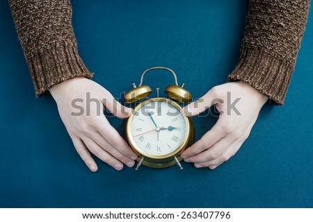 Alarm clock on businessman\'s hand, Time over concept