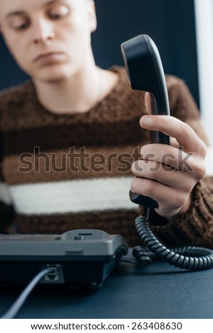 Business man using a black telephone in the office