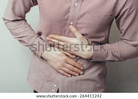 Young man suffering from a bad stomach ache pain