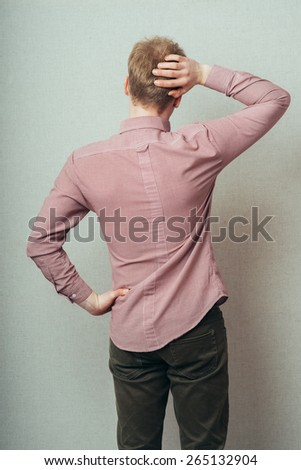 back view picture of a young business man scratching his head
