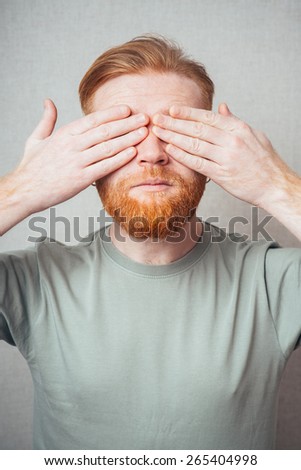 portrait of a bearded man closed his eyes with his hands
