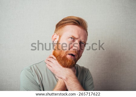 Young red bearded Man has pain in his throat