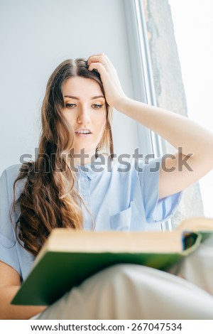 surprised or upset Girl reading book in the window