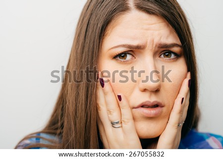 A young woman with a headache holding head, isolated on white background