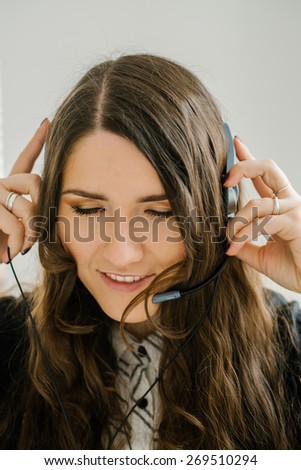 beautiful brunette girl talking on headphones with microphone