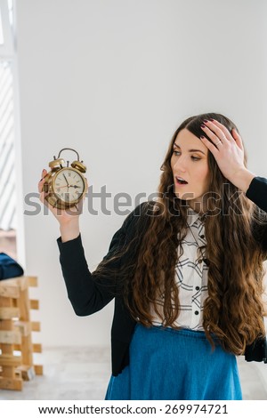 Closeup portrait woman extending hand to alarm clock. Human face expression, emotion, feeling.